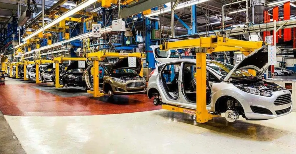 Car manufacturing process with assembly line and robotic machinery.webp