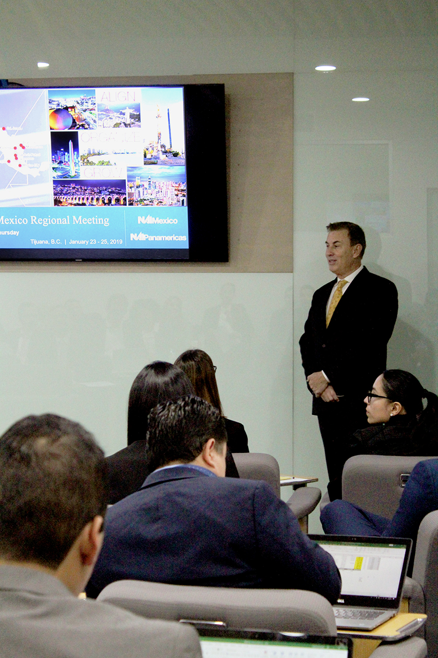 Business professional giving presentation to conference audience in a modern meeting room