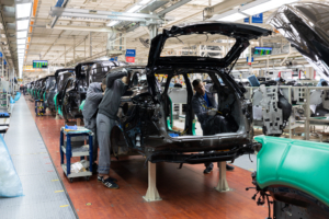Automotive assembly line with workers assembling cars in a factory setting